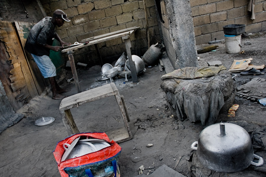 A Haitian man polishes an aluminium pot in the aluminium recycling shop on the street of Port-au-Prince, Haiti.