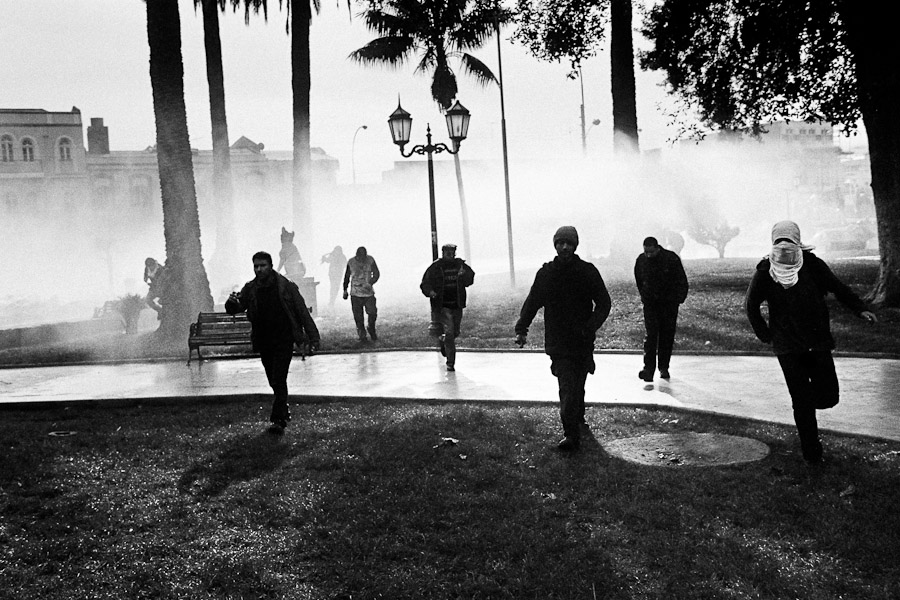 Chilean students run away from the tear gas attack lead by Chilean police during the anti-government protest in Valparaíso, Chile.