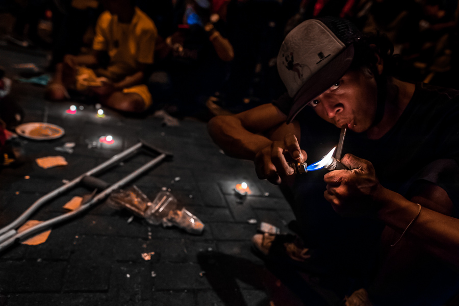 A young colombian man smokes “bazuco” (a raw cocaine paste) during the night in the street of Medellín, Colombia.