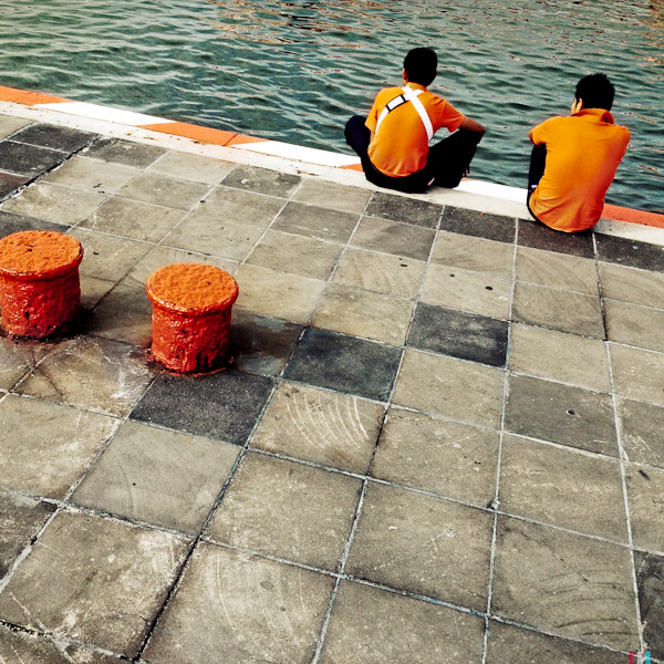 Mexican boys sit and relax on the wharf in the port of Veracruz, Mexico.