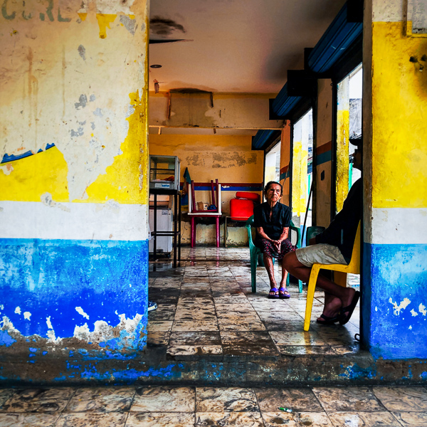 A Colombian woman sits in her small diner while waiting for customers from the neighbourhood to come, eat soup and leave again for the streets of Cartagena, Colombia.