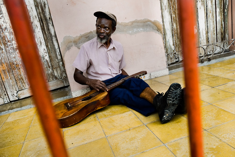 A Cuban musician, troubadour (trovador in Spanish), changing strings on his old guitar during the Carnival in Santiago de Cuba.