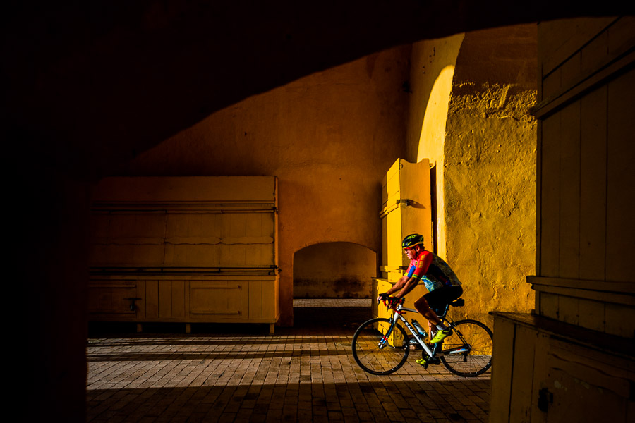 A Colombian cyclist rides his bicycle through the Clock Tower gate, the entrance to the colonial walled city, during the sunrise in Cartagena, Colombia.