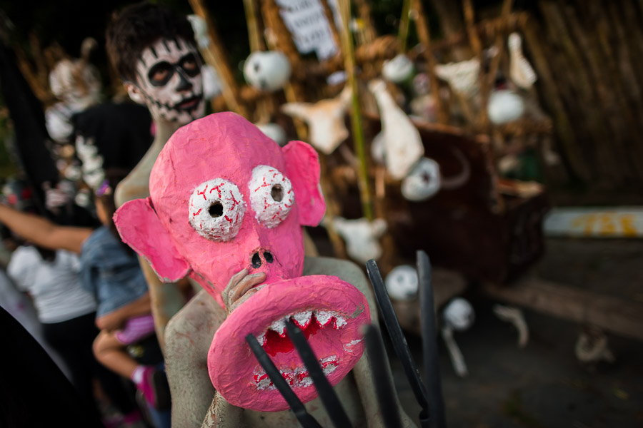 A Salvadoran boy, wearing a pink mask, performs an indigenous mythology character in the La Calabiuza parade at the Day of the Dead festivity in Tonacatepeque, El Salvador.