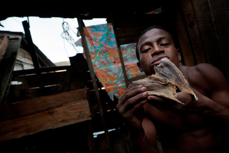 The Colombian fisherman eats a dried fish in Tumaco, Colombia.