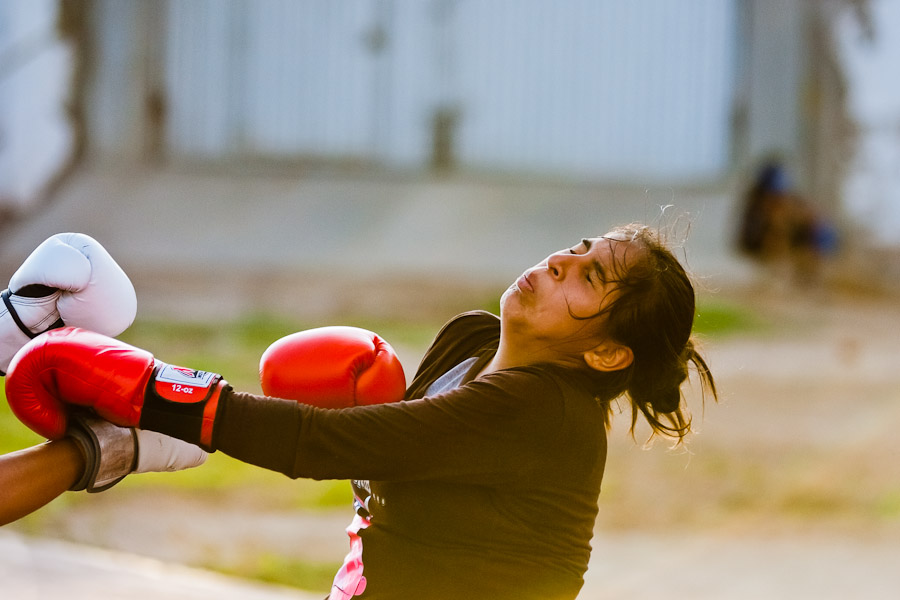 A Peruvian girl is seen being hit while training in the outdoor boxing school at the Telmo Carbajo stadium in Callao, Peru.