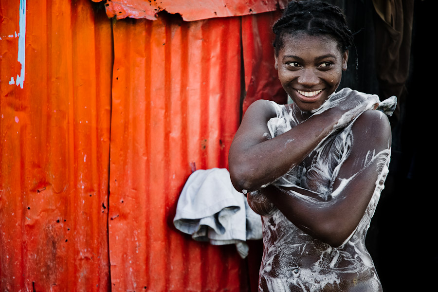 A young girl is having a bath in front of her parents house Port