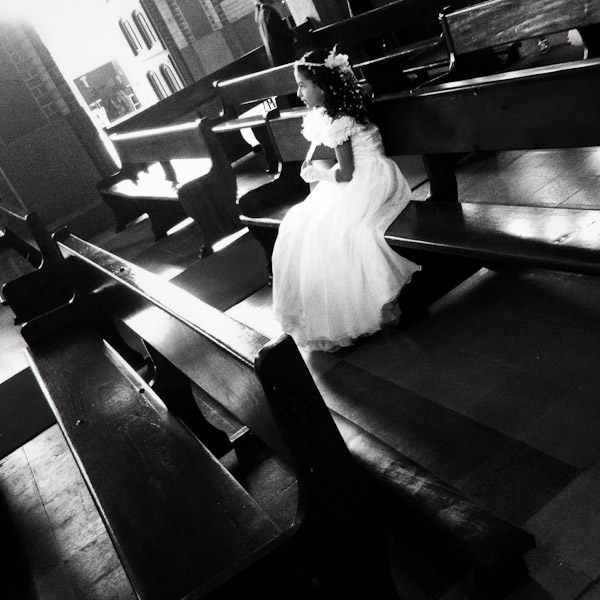 A young Colombian girl sits in the pew before taking part in the First Holy Communion ceremony in the church in Quimbaya, Colombia.