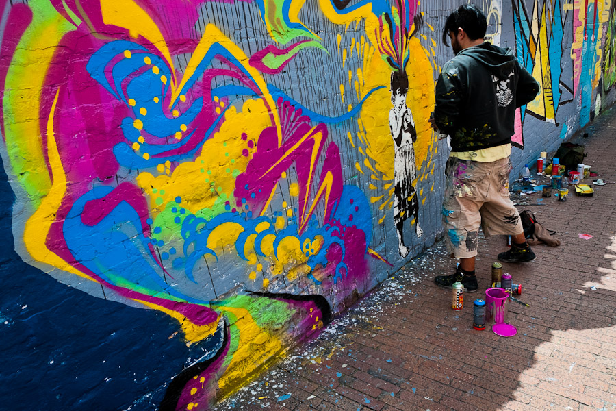 A Colombian street artist named Stinkfish sprays graffiti on the wall in La Candelaria, Bogotá.