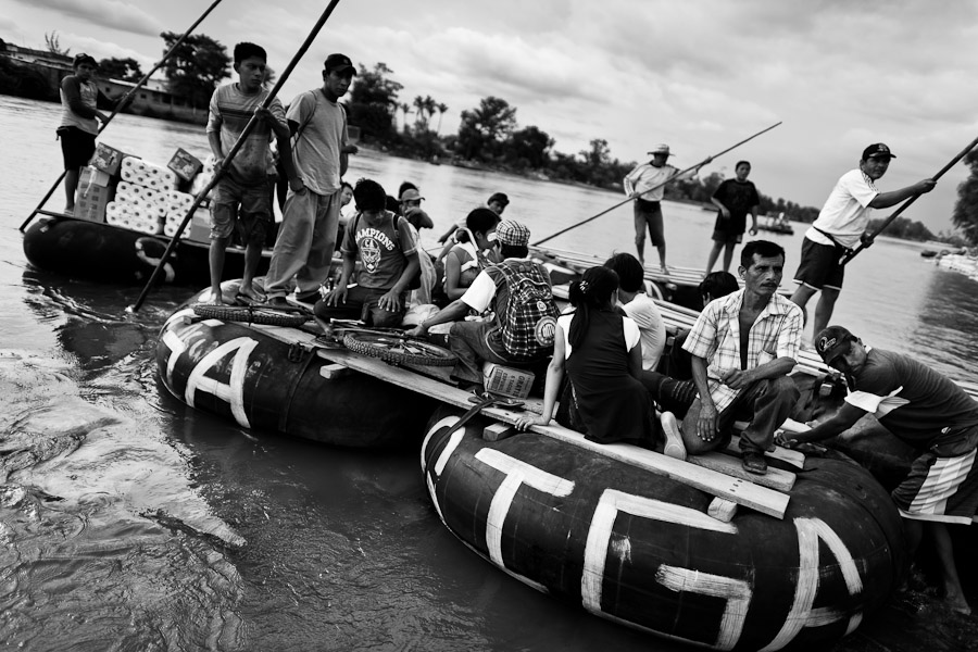 Makeshift inner tube rafts, carrying smuggled goods, border area workers and immigrants from Central America, cross the Suchiate river to Mexico from Tecún Umán, Guatemala.