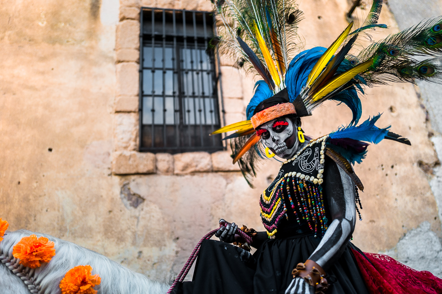 A Mexican girl, dressed as La Catrina and wearing an Aztec feather headdress, takes part in the Day of the Dead celebrations in Taxco de Alarcón, Guerrero, Mexico.