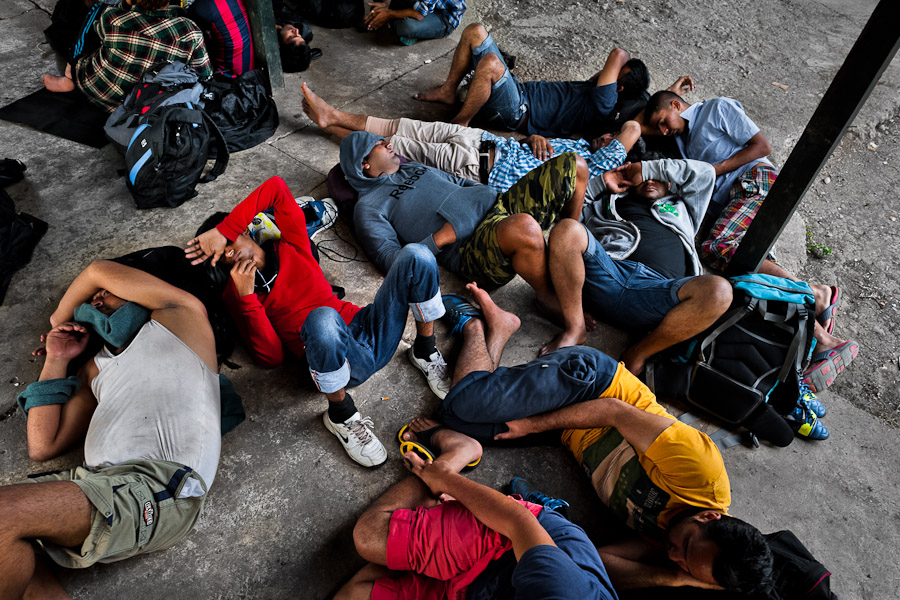 Nepalese immigrants, heading the southern U.S. border, lie exhausted on the ground after crossing the jungle of Darien gap in Panama.