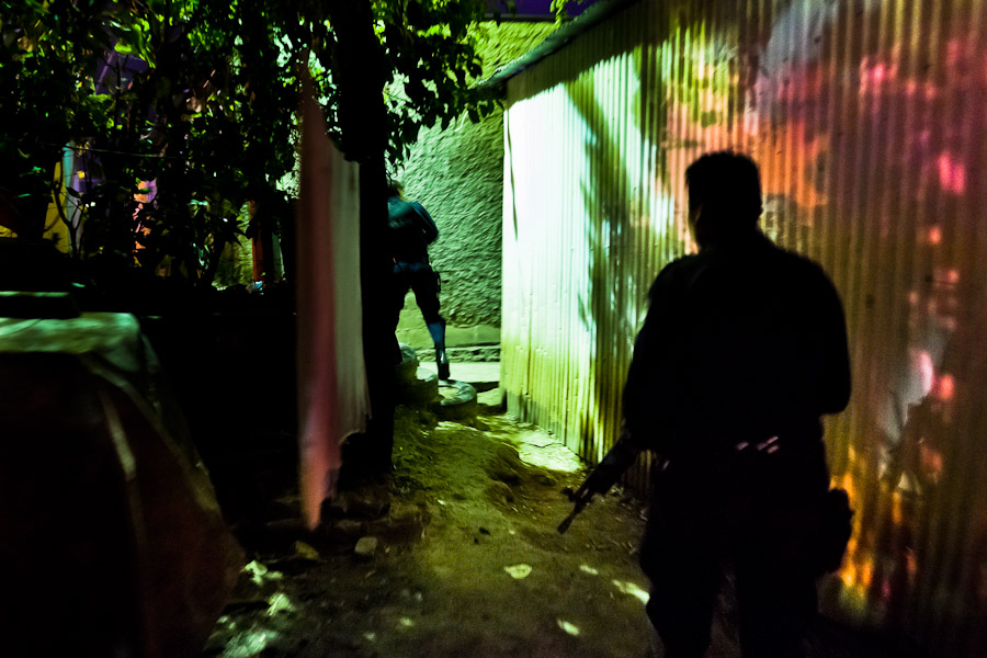 Policemen from the special emergency unit (Halcones) chase supposed gang members during the night in a gang neighbourhood of San Salvador, El Salvador.