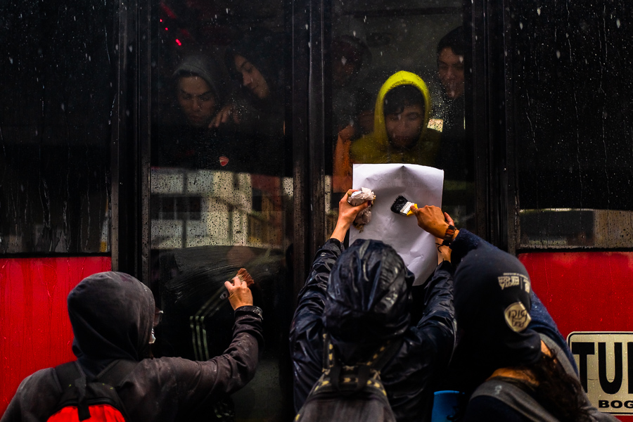 Radical students of the Universidad Nacional de Colombia attach a poster to a bus window during a protest march against government’s policies and corruption within the public educational system in Bogotá, Colombia.