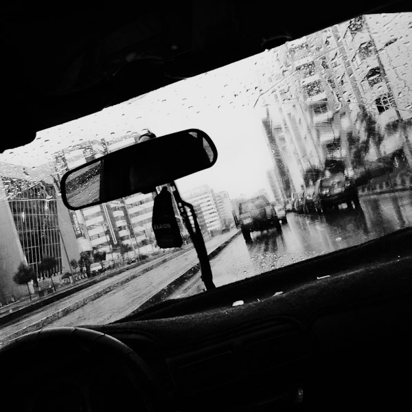 A city street with traffic seen through the taxi window during a heavy rain in Quito.