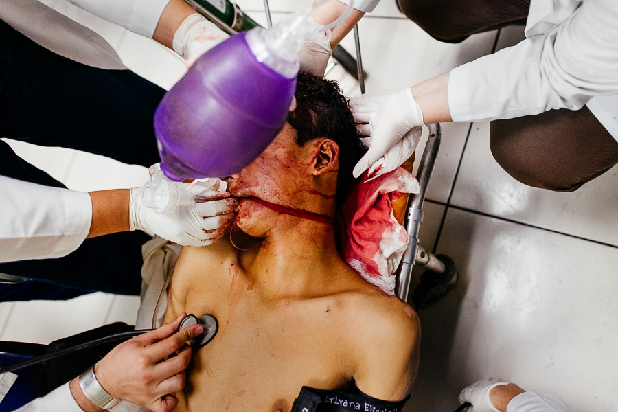 A team of emergency physicians provide a trauma resuscitation to a young gang member, injured by gunshots, in the emergency department of a public hospital in San Salvador, El Salvador.