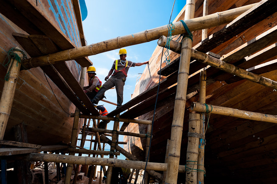 Ecuadorian shipbuilding workers provide maintenance to the traditional wooden fishing vessels in an artisanal shipyard on the beach in Manta, Ecuador.