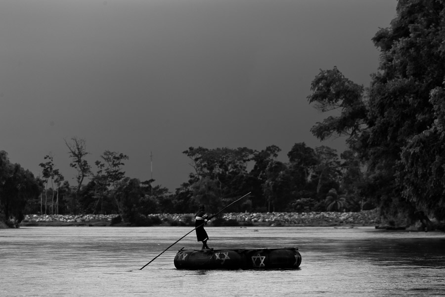 A makeshift inner tube raft, used for smuggling people and goods, crosses the Suchiate river from Mexico to Tecún Umán, Guatemala.