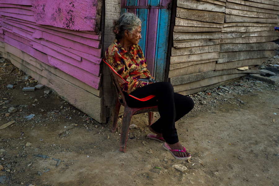 An Afro-Colombian woman sits on a chair in front of her wooden house in Olaya Herrera, a low social class neighborhood in Cartagena, Colombia.