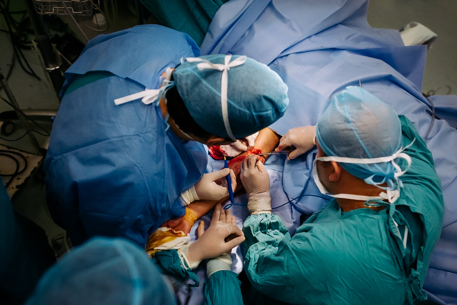 A team of surgeons remove a bullet from a young gang member’s arm during the life-saving surgery in the operating room of a public hospital in San Salvador, El Salvador.