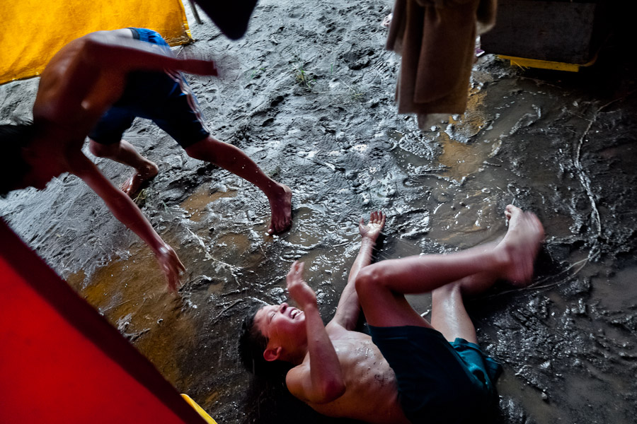 A Colombian boy falls into a mud during a friendly fight at the Circo Anny, a family run circus wandering the Amazon region of Ecuador.