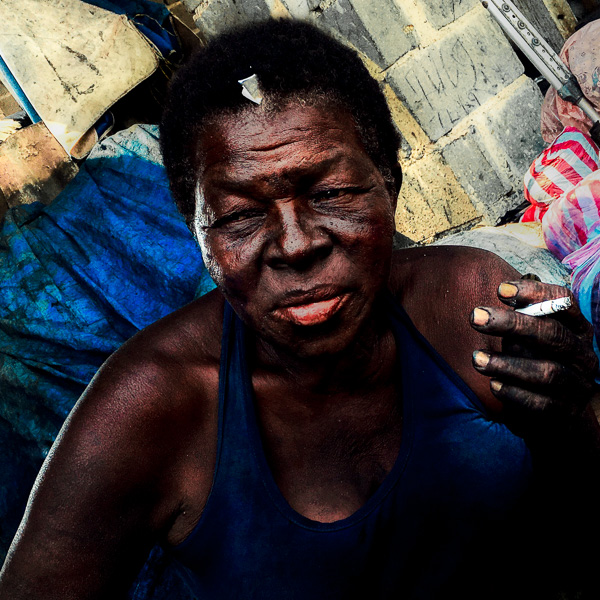 An Afro-Colombian coal vendor smokes a cigarette after having worked the whole day in the market of Bazurto, Cartagena, Colombia.