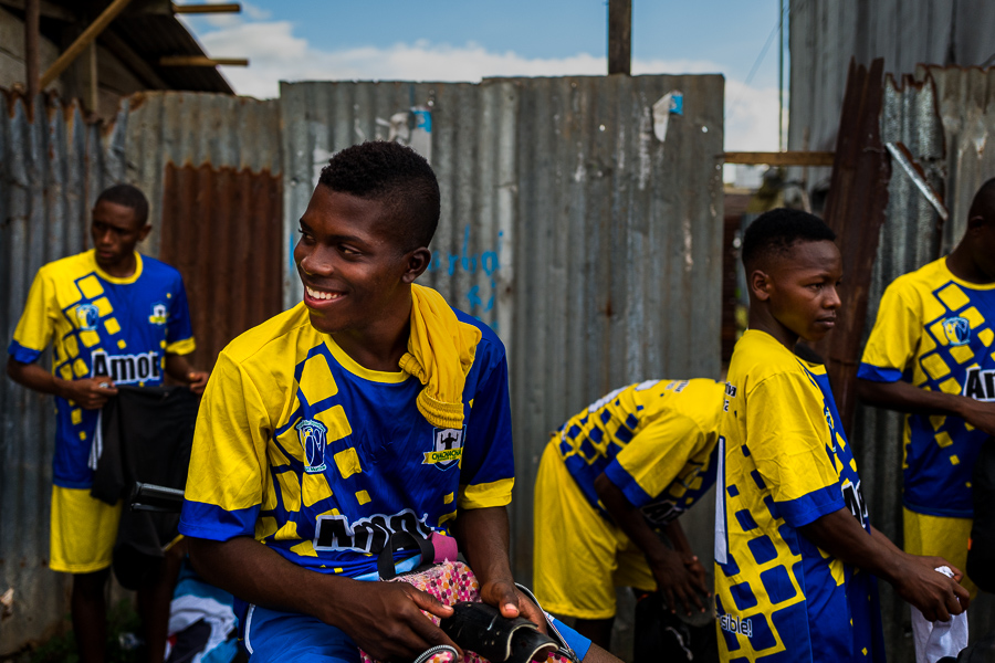 Afro-Colombian boys wear football boots before playing a football match on a dirt field in Quibdó, Chocó, the Pacific department of Colombia.
