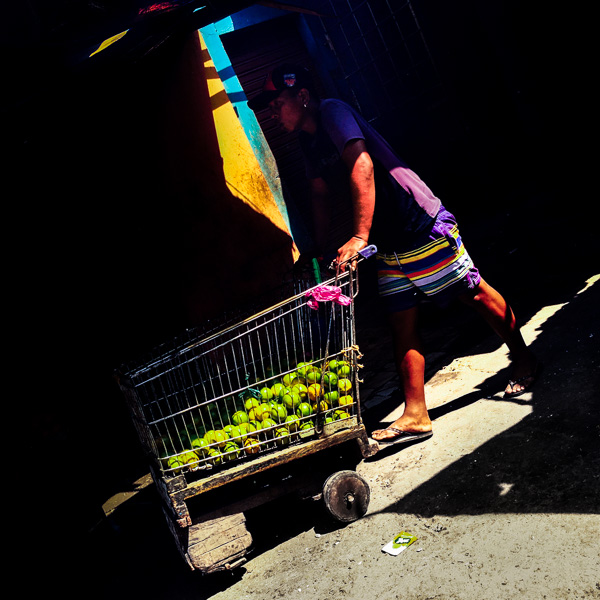 A Colombian worker pushes a customized supermarket cart, loaded with fresh limes, at the market of Bazurto in Cartagena, Colombia.