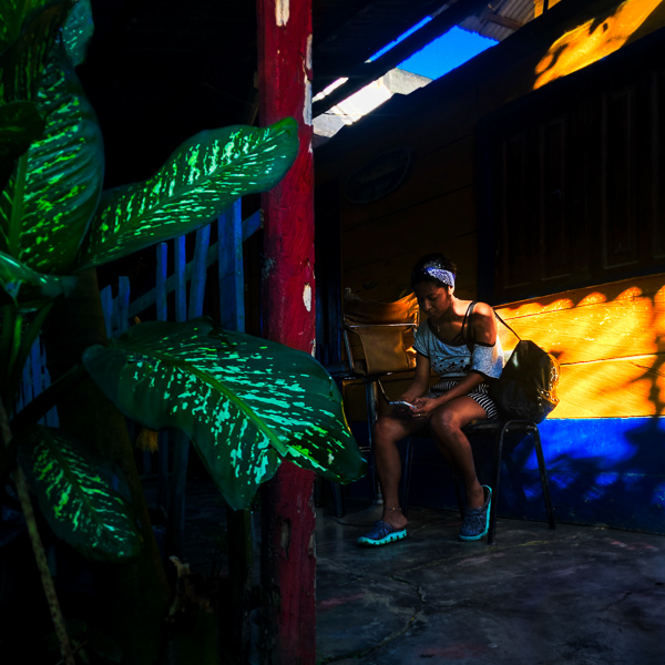 A young Afro-Colombian woman looks at her cell phone in Necoclí, Colombia.