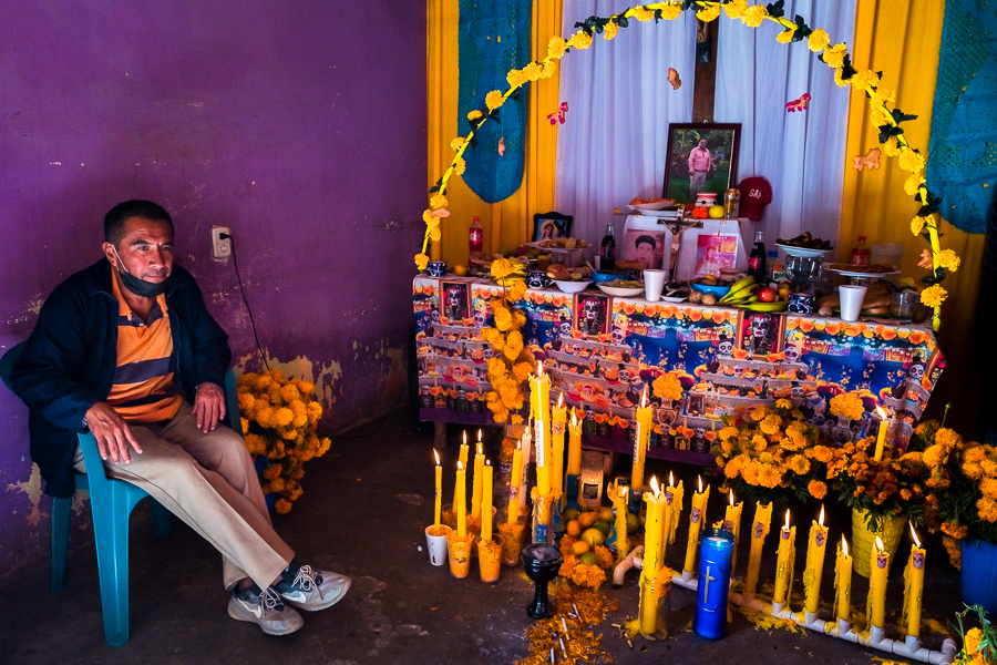 A Mexican man sits in front of an altar of the dead (Altar de Muertos), a religious site honoring the deceased, during the Day of the Dead celebrations in Tlapa de Comonfort, Guerrero, Mexico.