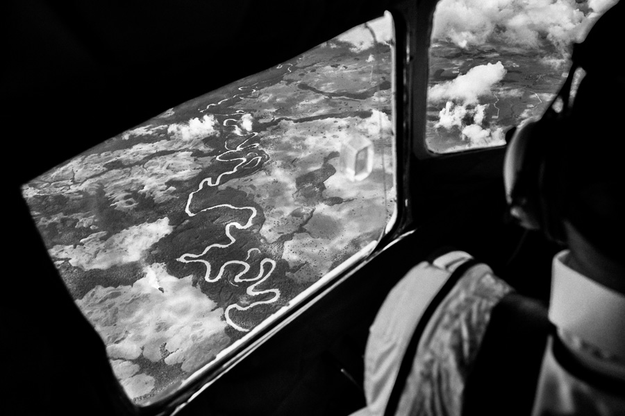 Vast expanses of land, covered by Amazonian rainforest and traversed by rivers, are seen from the cockpit of a Douglas DC-3 aircraft, flying over the remote department of Guainía, Colombia.
