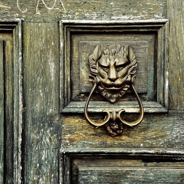 Antique door knockers on the wooden doors of colonial houses in Morelia, Mexico.