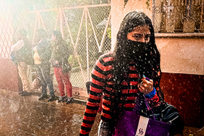 A Mexican girl walks in the rain