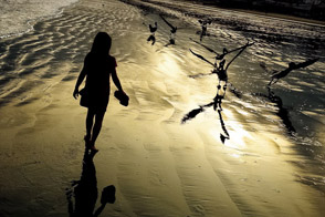 Girl walks on the beach at the sunrise (Manta, Ecuador)