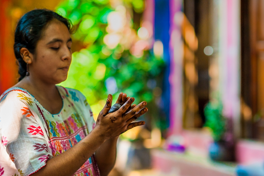 An Amuzgo indigenous woman rolls the raw cacao paste with hands into balls, used for hot chocolate preparation, in artisanal chocolate manufacture in Xochistlahuaca, Guerrero, Mexico.