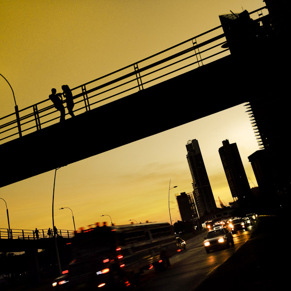 A Panamanian couple talk on the pedestrian bridge across Avenida Balboa, a seafront highway going through the commercial and financial center of Panama City, Panama.