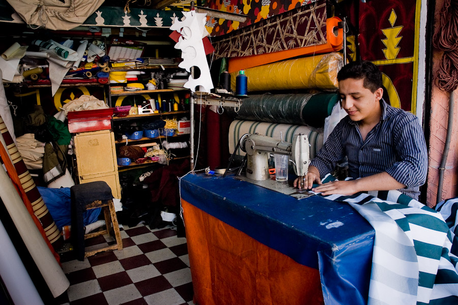 A young Moroccan boy sews an awning in the manufacture in Marrakech, Morocco.