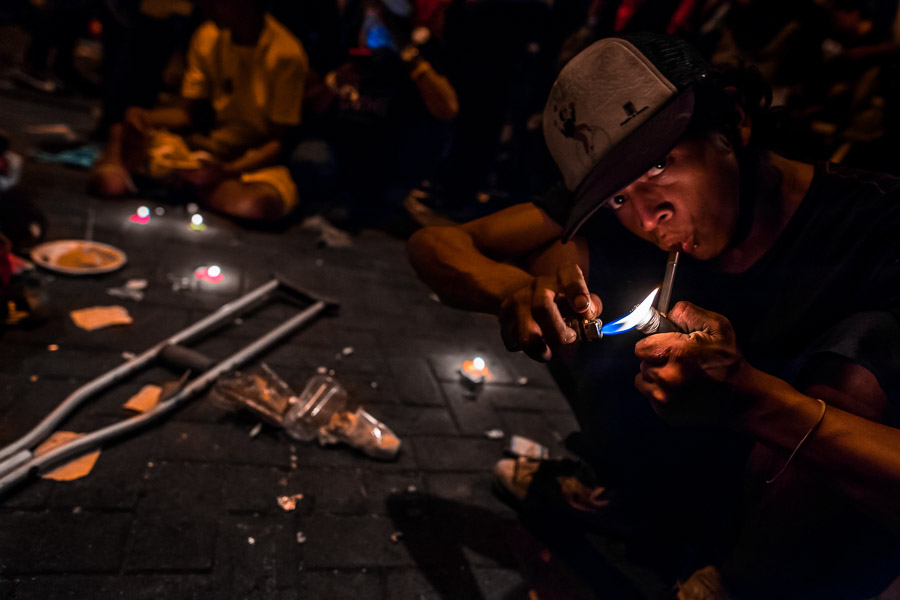 A young Colombian man smokes a pipe loaded by “bazuco” (a raw cocaine paste) during the night in the center of Medellín, Colombia.
