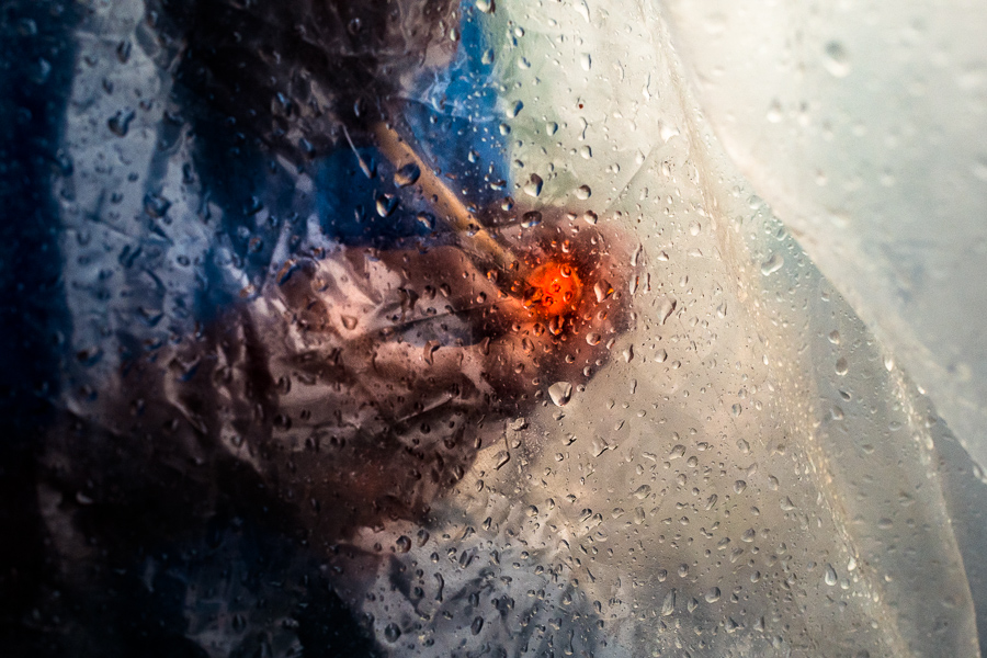 Colombian men smoke “bazuco” (a raw cocaine paste), hidden inside a large plastic bag in the center of Medellín, Colombia.