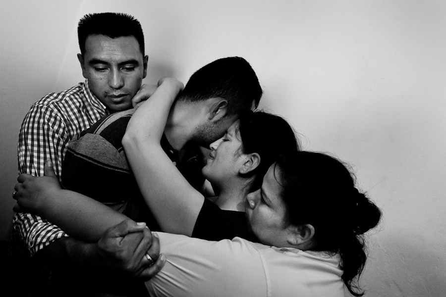 A Colombian couple, hugged by missionaries, cry during the religious healing ritual performed at a house church in Bogota, Colombia.