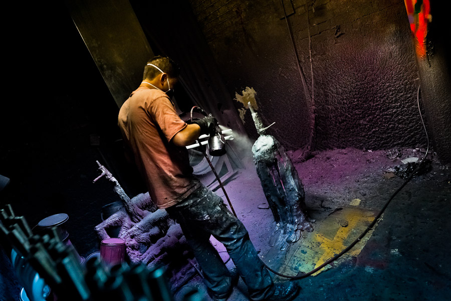 A bicycle painter works on a bike frameset in the paint booth of a bicycle workshop in Bogota, Colombia.