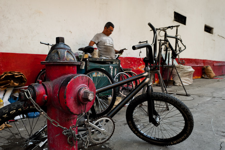 A Colombian service man fixes a BMX bike in a bicycle repair shop on the street in Cali, Colombia.