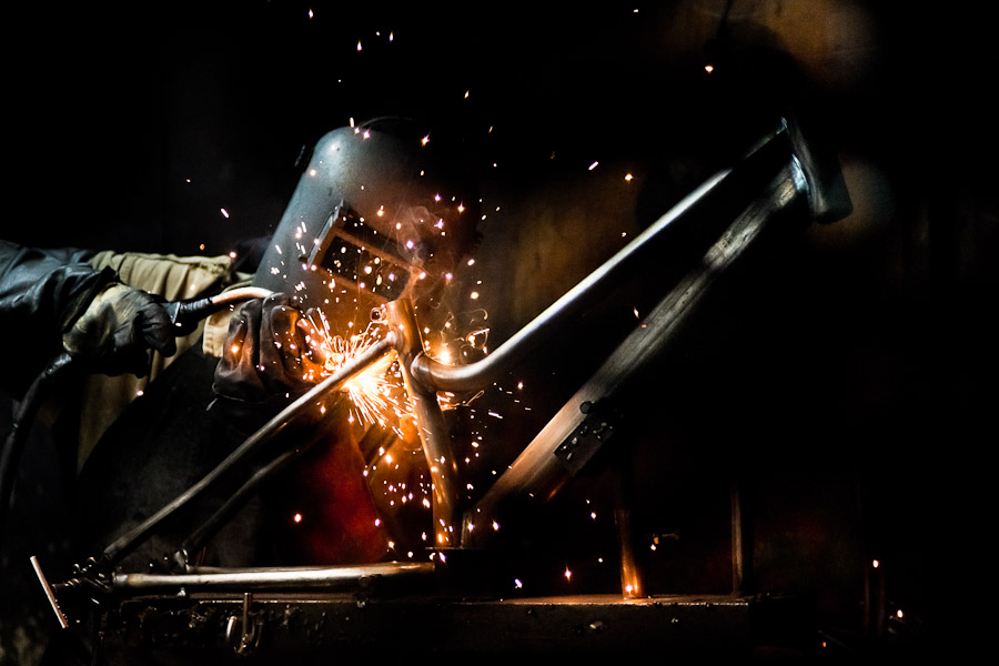 A bicycle welder works on a bike frame fixed on a welding jig in a small scale bicycle factory in Bogota, Colombia.