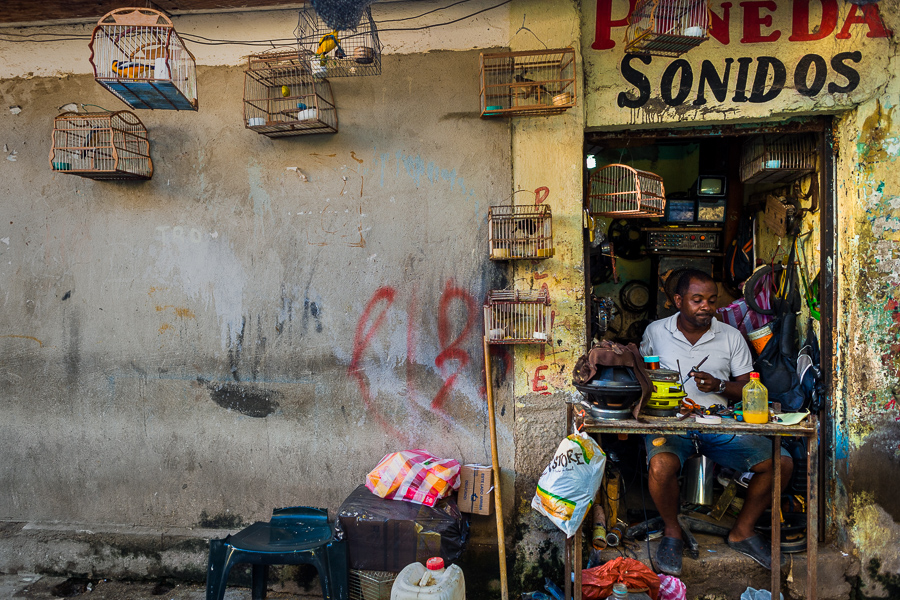 A Colombian bird vendor repairs old speakers in his workshop in the bird market in Cartagena, Colombia.