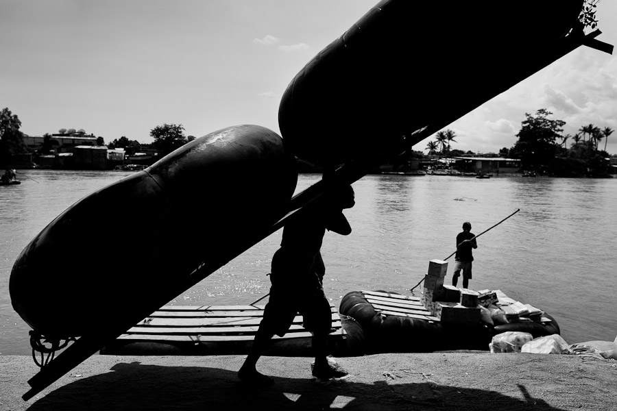 A Guatemalan boatman carries a makeshift inner tube raft, used for smuggling people and goods, on the bank of the Suchiate river in Tecún Umán, Guatemala.