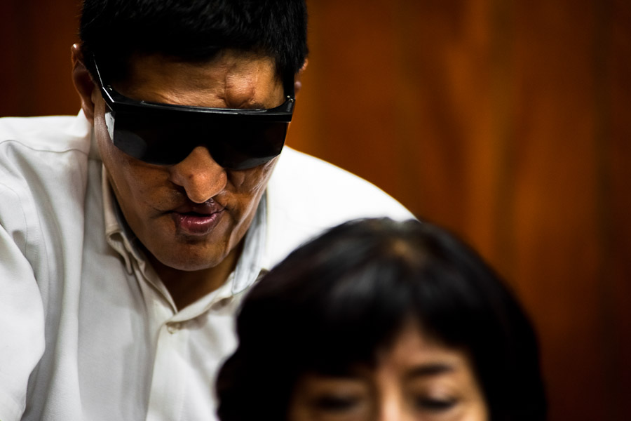 A blind man massages a client's back at Unión Nacional de Ciegos del Perú, a social club for the visually impaired in Lima, Peru.