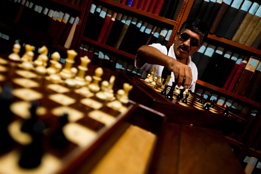 A blind man plays chess in the library of Unión Nacional de Ciegos del Perú, a social club for the visually impaired in Lima, Peru.