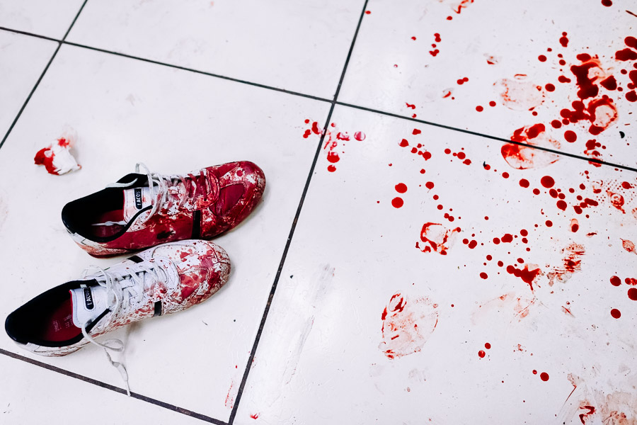 Bloodied sneakers of a deadly injured gang member, lying next to a splash of blood, are seen on the floor of the emergency department of a public hospital in San Salvador, El Salvador.