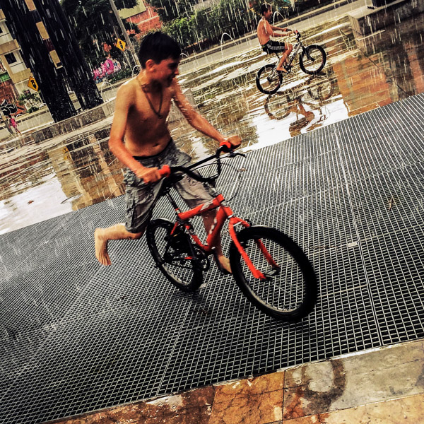 Colombian boys perform tricks on BMX bikes during the rain in Parque Chimeneas, Itagüí, Colombia.