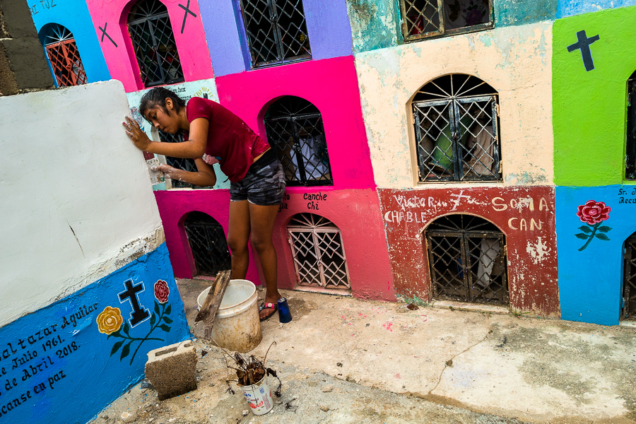 A Mayan girl repairs parging of a niche during the bone cleansing ritual at the cemetery in Pomuch, Mexico.